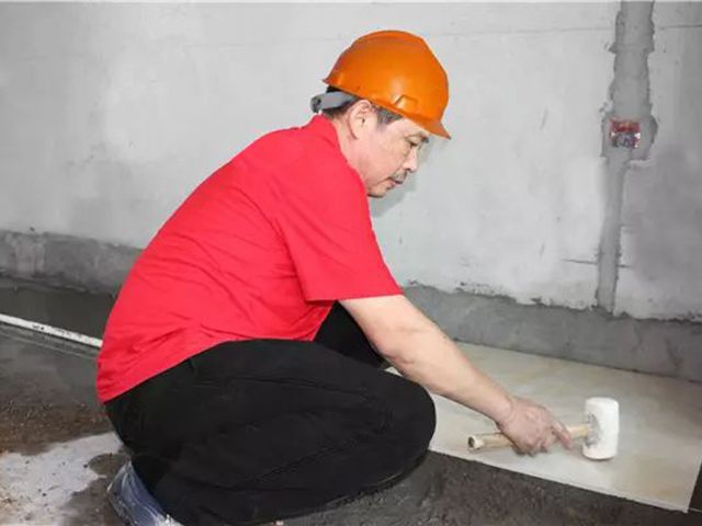 5鋪貼地磚時，磚的背面朝上批刮水泥油，并按箭頭所指方向統(tǒng)一鋪貼，用橡皮錘從中到邊，由重到輕敲實.jpg